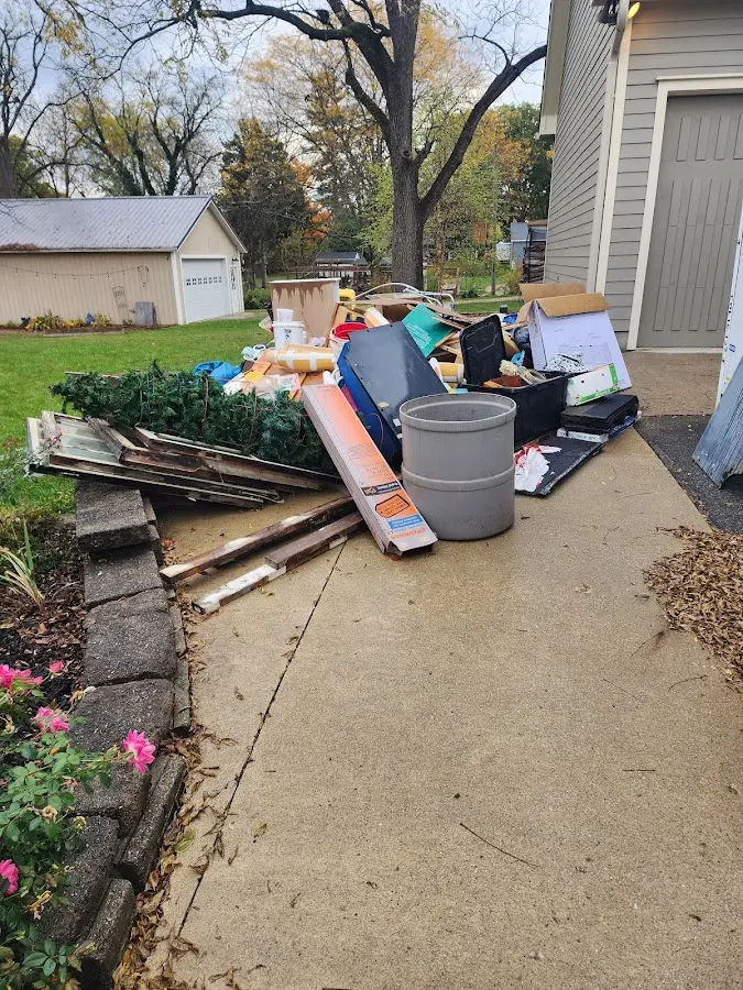 Dumpster being loaded with debris for 12 Yard Dumpster Rental in Duluth